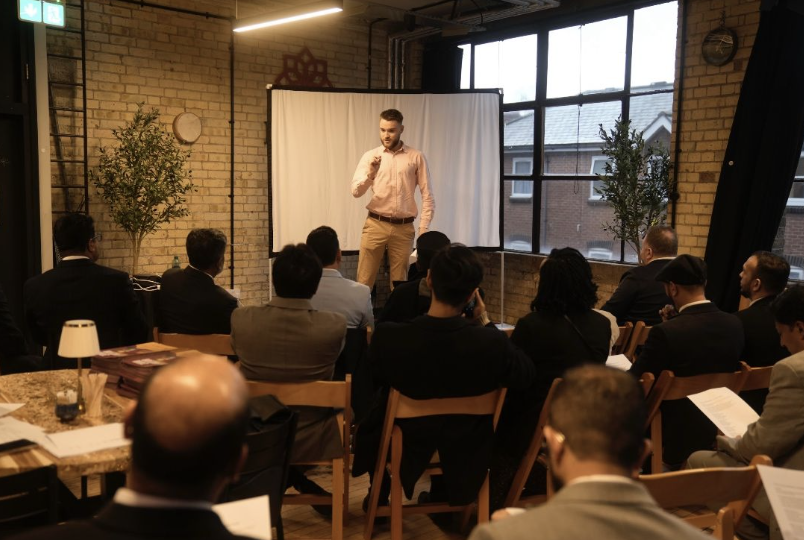 Portrait of Ewan Leo Horton speaking to an audience in East London